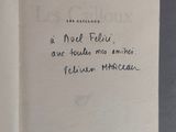un livre ouvert posé sur une table, sur lequel se trouve une note manuscrite