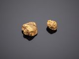 two gold nuggies on a black surface