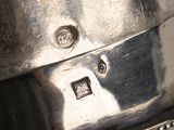 a silver pot sitting on top of a wooden table