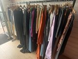 clothes hanging on a rack in front of a window in a room