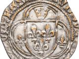 a silver coin with an image of a shield on it