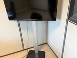 un téléviseur à écran plat sur un support dans le coin d'une pièce