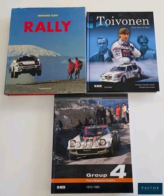 three books on a white table with a picture of a rally car and a group of people