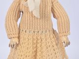 an image of a doll is wearing a yellow dress and a hat