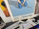 a picture of a man holding a knife next to a pile of postcards