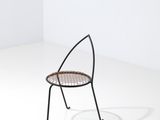une image représentant une chaise dans une pièce blanche, avec une ombre sur le sol