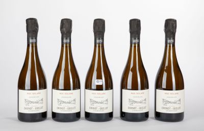 six bouteilles de vin sont alignées sur une surface blanche