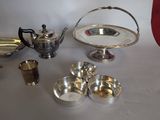 a table with silver dishes and cups on it