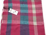a close up of a pink and blue plaid scarf with a tag on it
