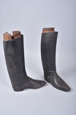 une paire de bottes en cuir noir avec des talonnettes en bois, sur fond blanc