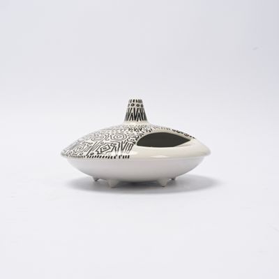 un vase blanc orné d'un motif noir et blanc