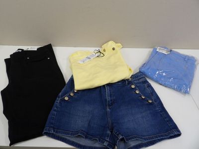 three pairs of shorts and a t - shirt sitting on a table