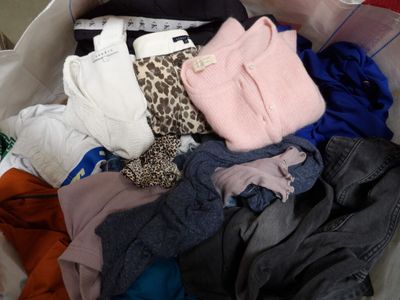 a bag full of clothes that is sitting on the floor