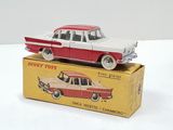 a red and white toy car sitting on top of a box