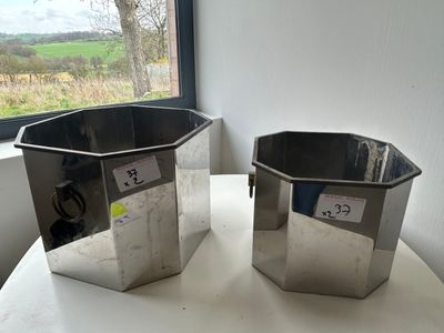 two metal containers sitting on a table next to a window