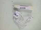 un cordon blanc branché à un chargeur posé sur une table