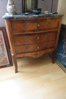 une commode avec un plateau en marbre sur lequel est posé un vase