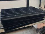 a pile of black plastic sheets on a pallet in a room