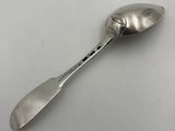 an old spoon with a metal handle sitting on a white surface