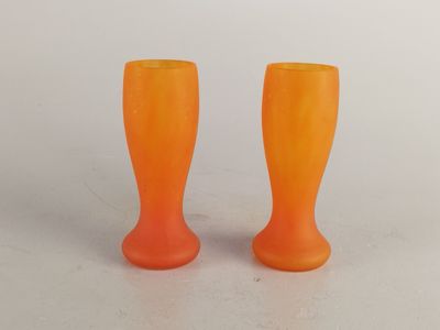 deux vases orange posés l'un à côté de l'autre sur une table