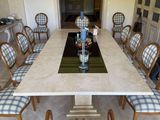 a table and chairs in a room with a chandelier in the background