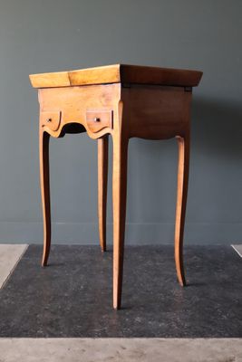 une petite table en bois surmontée d'un tiroir