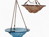 deux bols en verre bleu suspendus à une corde sur un fond blanc