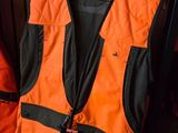 an orange vest with a tag on it sitting on a shelf