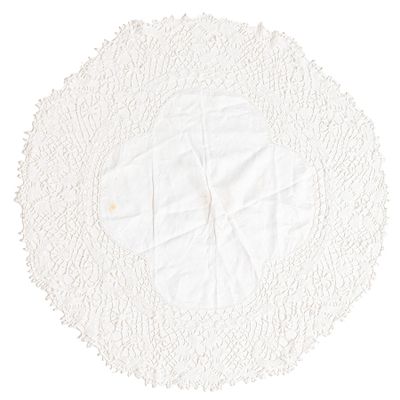 un napperon blanc au crochet posé sur un napperon blanc, le tout sur un fond blanc