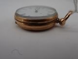 a small gold pocket watch with a chain around it