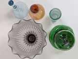 four different colored glass vases sitting on a table