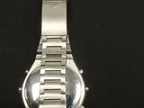 a close up of a watch on a black surface with a black background