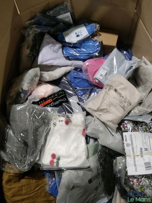 une boîte en carton remplie de vêtements, posée par terre