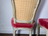 pair of chairs with red velvet upholstered seats in a white room