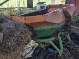 a green and orange wheelbarrow sitting on a pile of hay