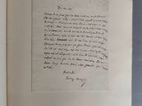 un livre ouvert, sur lequel repose une lettre manuscrite, posé sur une table