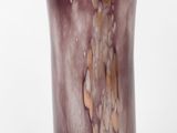 un gros plan d'un vase en verre violet posé sur une surface blanche
