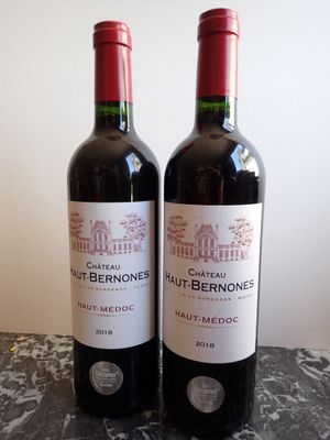 two bottles of red wine sitting on a table