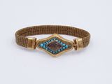 un gros plan d'un bracelet orné d'une pierre bleue