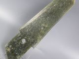 green stone knife on clear acrylic stand on white background