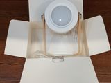 a white box with a light inside of it on a wooden floor