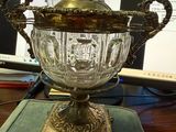 un vase en verre posé sur une table, avec un ordinateur en arrière-plan
