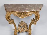 une table avec un plateau en marbre et un cadre doré