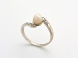 une image d'une bague en perles et diamants sur fond blanc