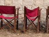 several red and green chairs sitting in a row in a field