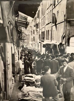 black and white photograph of a crowd of people walking down a street