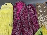 Plusieurs écharpes de différentes couleurs sont alignées sur une surface grise
