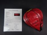 a red heart shaped bag with a note attached to it