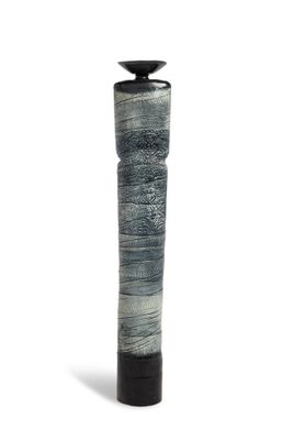 un vase noir et blanc posé sur une surface blanche