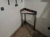 une petite table dans un coin de la salle de bains
